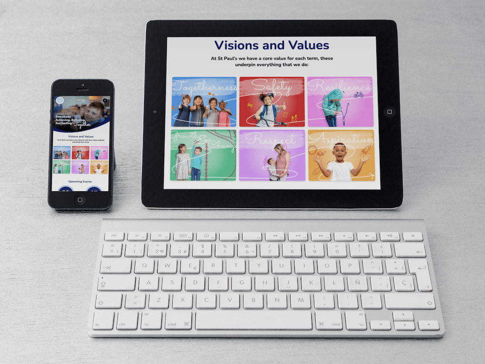 Tablet and iPhone on a desk in an office above an Apple keyboard, showing St Paul's homepage